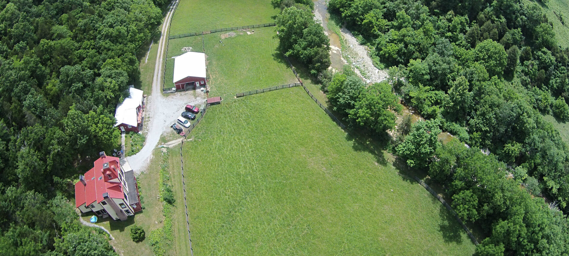 Arial view of the farm shows fenced green paddocks and the outline of the Otter Creek