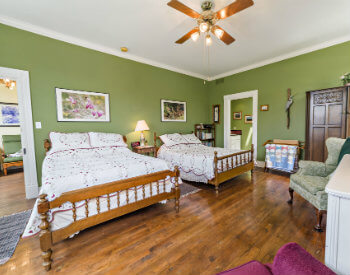 The sage green Meadow Room has two double beds and two comfortable chairs